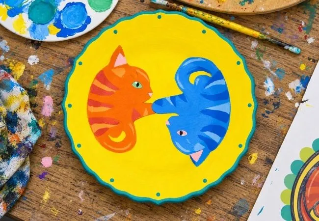Hand-painted ceramic plate featuring colorful cat designs
