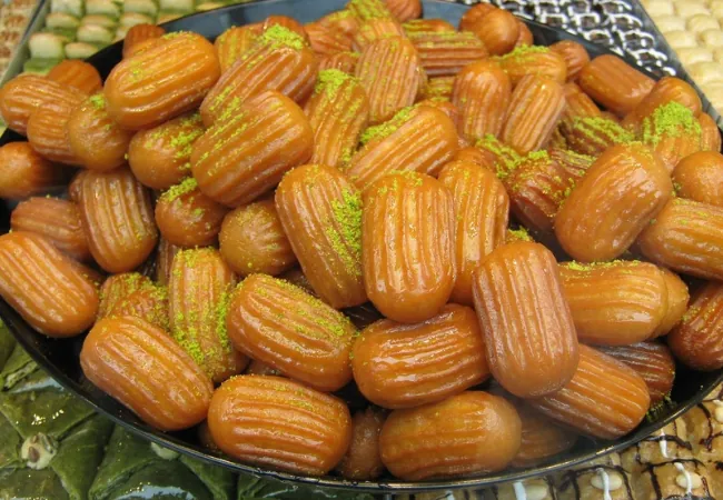 Traditional Turkish tulumba dessert topped with pistachio