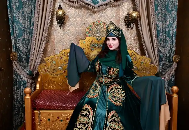 Ottoman woman costume photo experience with traditional green royal dress and throne setting