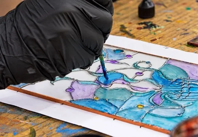Close-up of blue floral stained glass painting in progress